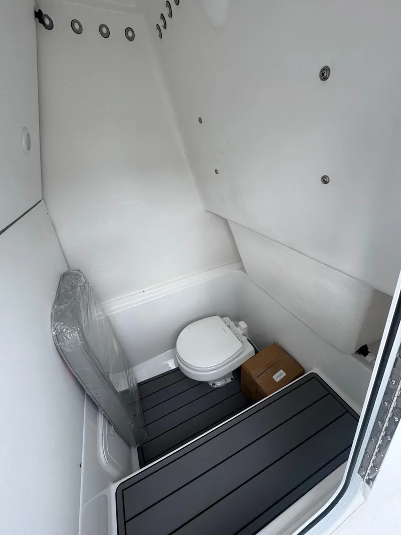 Slide: The Image of 2025 Cape Horn 28 XS boat interior with compact marine toilet and storage. - 32