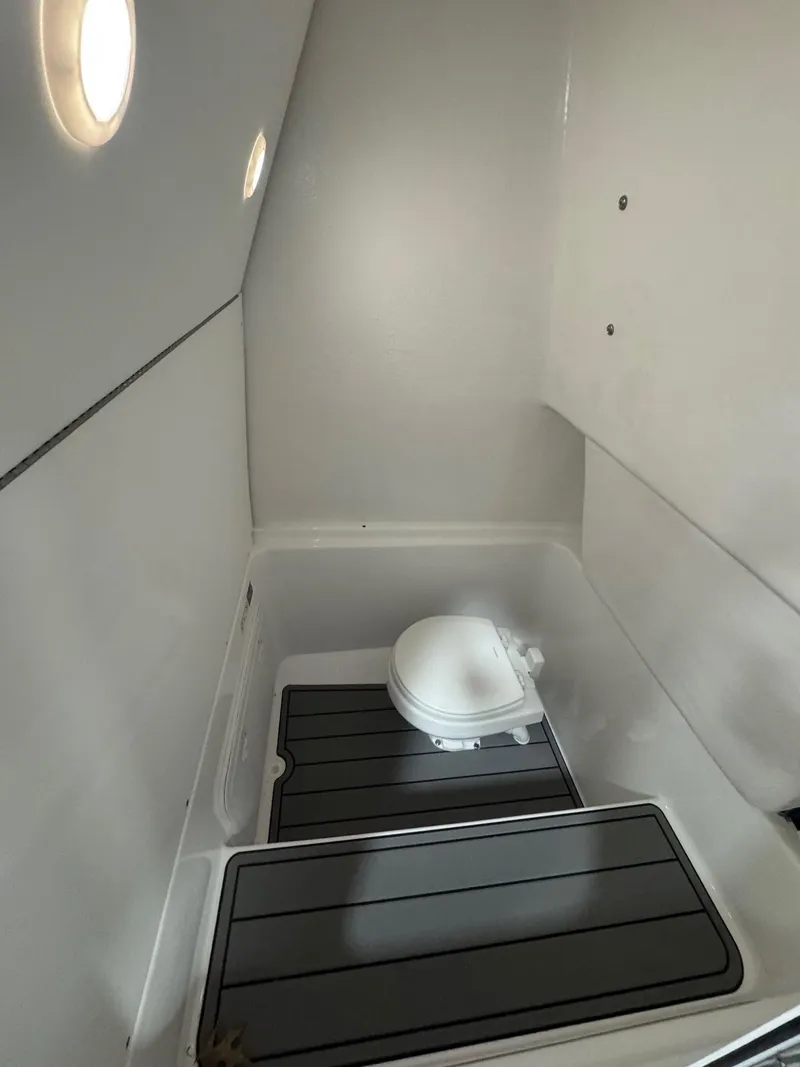 Slide: The Image of Interior of 2025 Cape Horn 28 XS boat, featuring a compact marine toilet. - 42