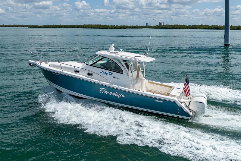 Slide: The Image of 2018 Pursuit OS 385 Offshore boat cruising on open water, displaying American flag. - 0