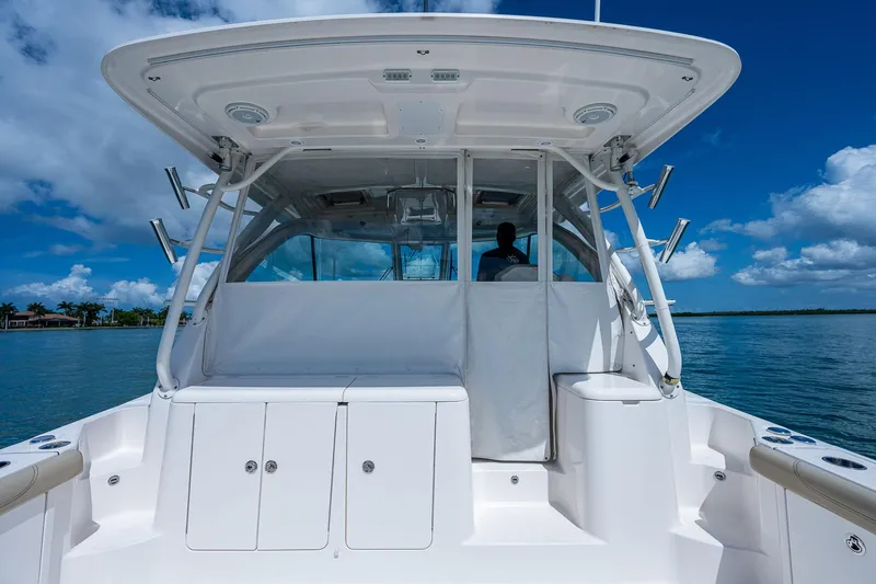 Slide: The Image of 2018 Pursuit OS 385 Offshore boat, rear view, on calm water under blue sky. - 13