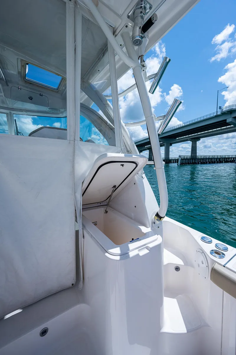 Slide: The Image of 2018 Pursuit OS 385 Offshore boat interior near a bridge on a sunny day. - 15
