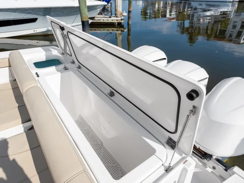 Slide: The Image of 2018 Pursuit OS 385 Offshore boat with open storage compartment, docked by the water. - 19