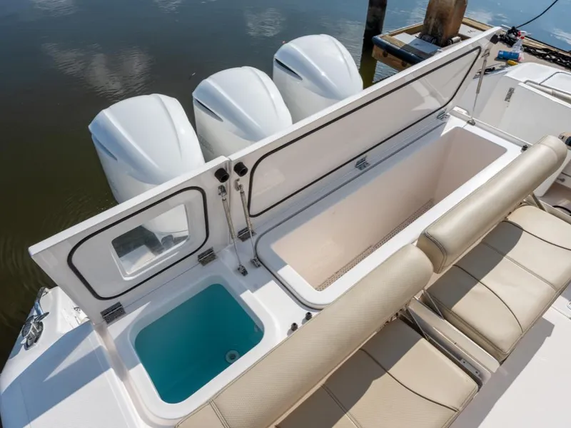 Slide: The Image of 2018 Pursuit OS 385 Offshore boat with open storage compartment and triple outboard engines. - 20