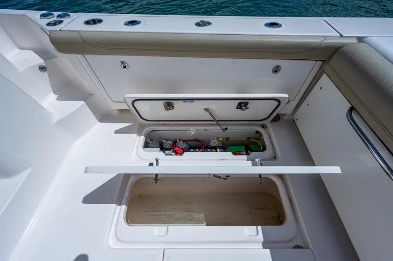 Slide: The Image of 2018 Pursuit OS 385 Offshore boat storage compartments with open hatches, showcasing interior space. - 21