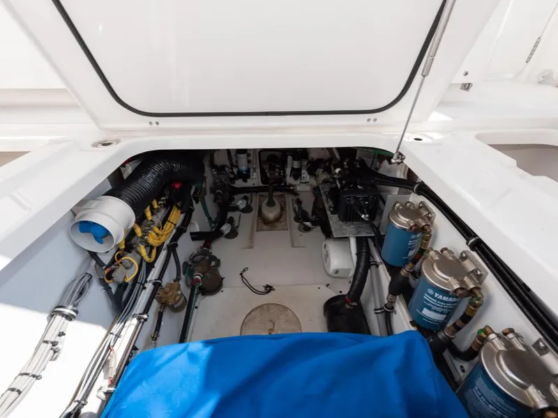 Slide: The Image of Engine compartment of a 2018 Pursuit OS 385 Offshore boat, showcasing mechanical components. - 25