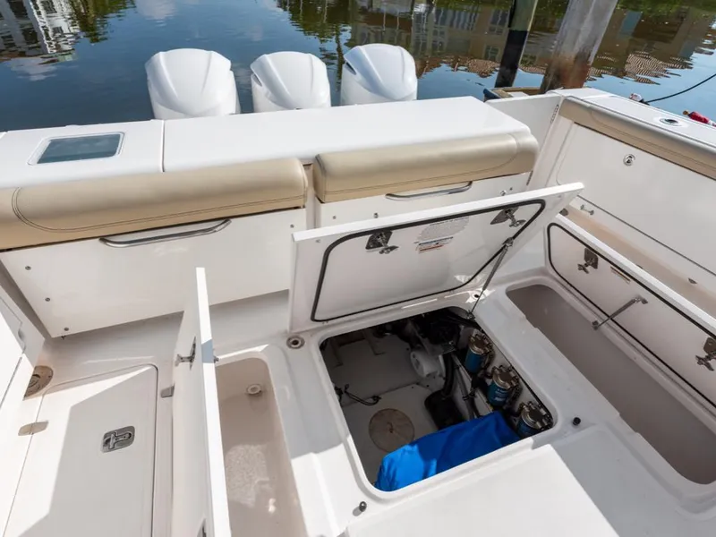 Slide: The Image of 2018 Pursuit OS 385 Offshore boat deck with open storage compartments and engine access. - 26