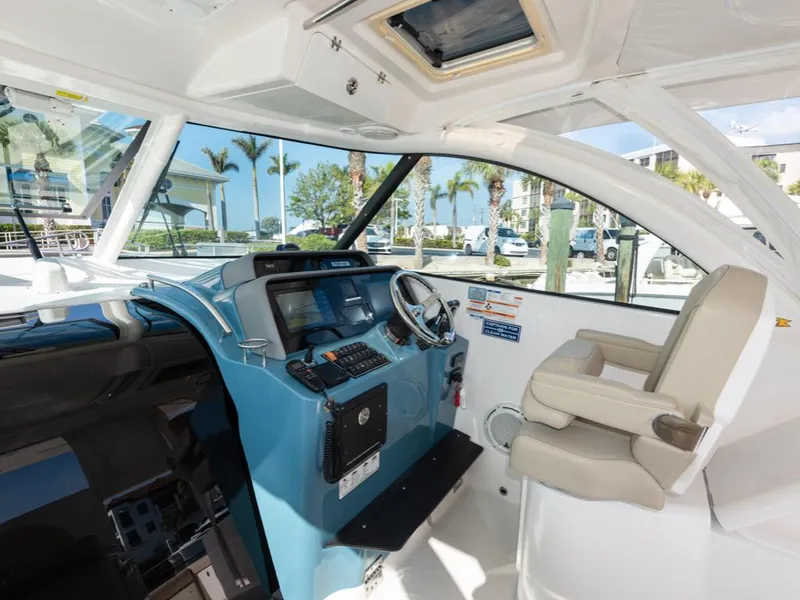 Slide: The Image of 2018 Pursuit OS 385 Offshore boat interior with helm, steering wheel, and captain's chair. - 28