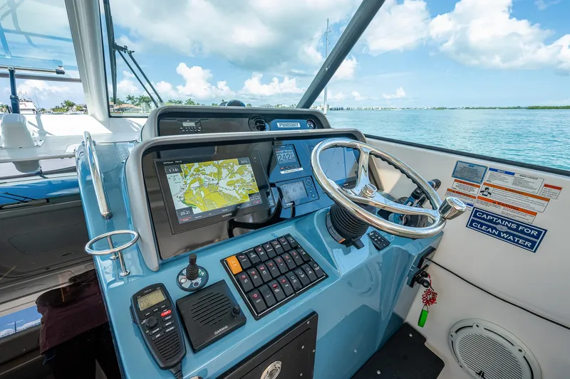 Slide: The Image of Helm of 2018 Pursuit OS 385 Offshore boat with navigation equipment and steering wheel. - 30