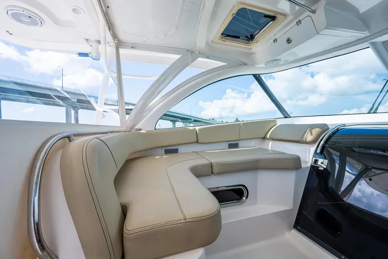 Slide: The Image of 2018 Pursuit OS 385 Offshore boat interior with beige seating and panoramic windows. - 32