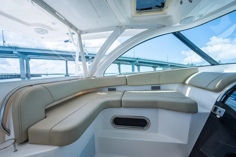 Slide: The Image of 2018 Pursuit OS 385 Offshore boat interior with beige seating and bridge view. - 33