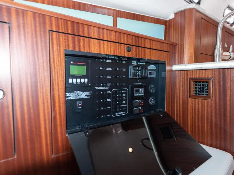 Slide: The Image of Control panel inside 2018 Pursuit OS 385 Offshore boat, featuring wood paneling and modern instrumentation. - 43