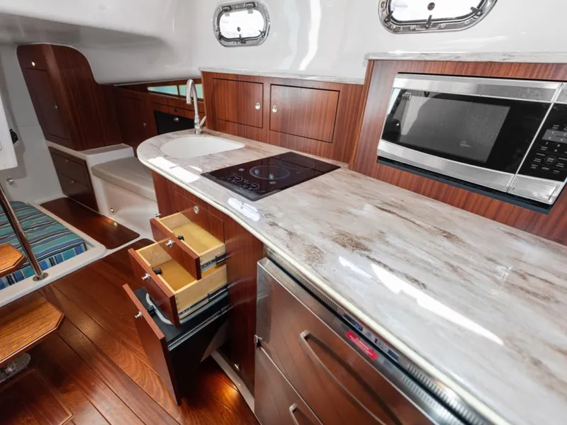 Slide: The Image of 2018 Pursuit OS 385 Offshore yacht kitchen with modern appliances and wooden cabinetry. - 44