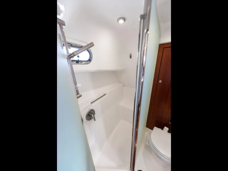 Slide: The Image of Bathroom interior of 2018 Pursuit OS 385 Offshore boat, featuring shower and toilet. - 46
