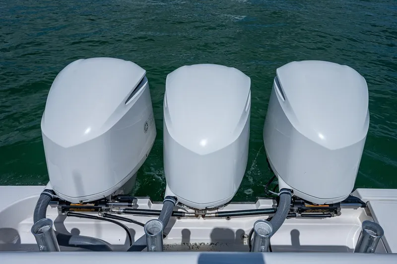 Slide: The Image of Three outboard motors on a 2018 Pursuit OS 385 Offshore boat in water. - 49