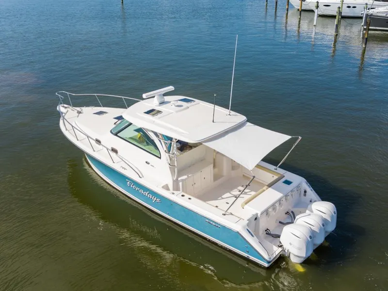 Slide: The Image of 2018 Pursuit OS 385 Offshore boat on water, featuring triple outboard engines. - 6
