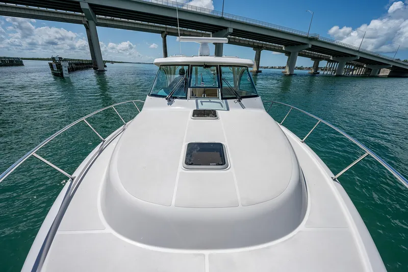 Slide: The Image of 2018 Pursuit OS 385 Offshore boat on water near a bridge, sunny day. - 7