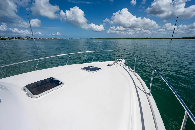 Slide: The Image of 2018 Pursuit OS 385 Offshore boat on calm water under a blue sky with clouds. - 8