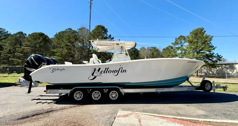 Slide: The Image of 2006 Yellowfin 34 Offshore boat on trailer, parked outdoors under clear blue sky. - 1