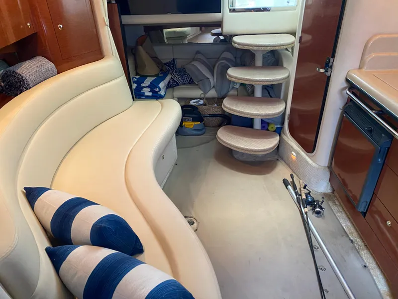 Slide: The Image of Interior of 2003 Sea Ray 320 Sundancer with curved seating and striped pillows. - 12