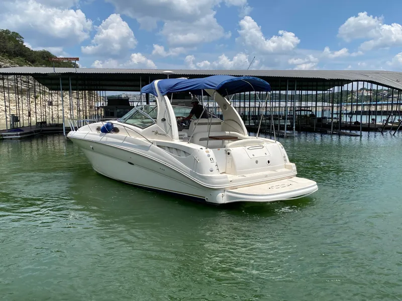 Slide: The Image of 2003 Sea Ray 320 Sundancer boat docked on calm water under a blue sky. - 5