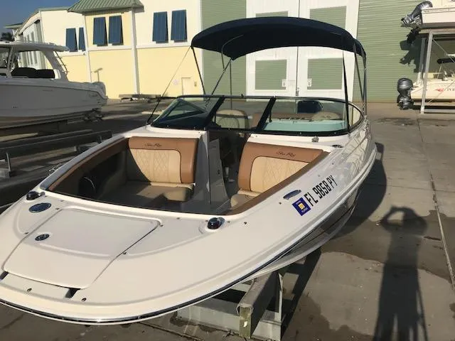 Slide: The Image of 2015 Sea Ray 220 Sundeck Outboard boat with canopy, docked outdoors. - 13