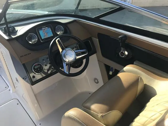 Slide: The Image of 2015 Sea Ray 220 Sundeck Outboard boat cockpit with steering wheel and dashboard controls. - 15