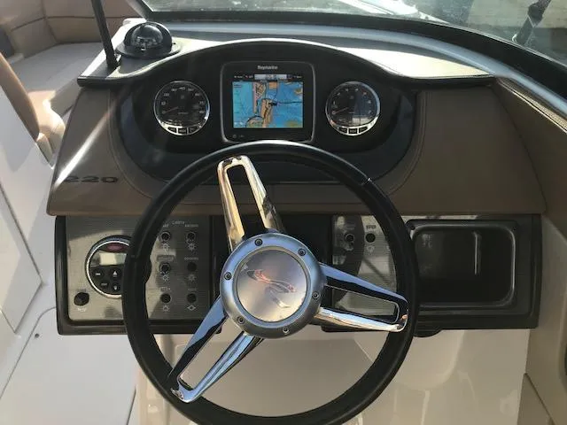 Slide: The Image of 2015 Sea Ray 220 Sundeck Outboard dashboard with steering wheel and navigation display. - 16