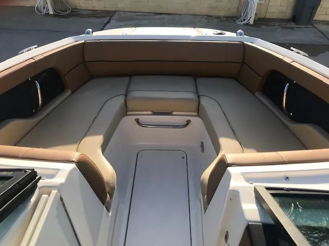 Slide: The Image of 2015 Sea Ray 220 Sundeck Outboard boat interior with tan seating and spacious layout. - 17