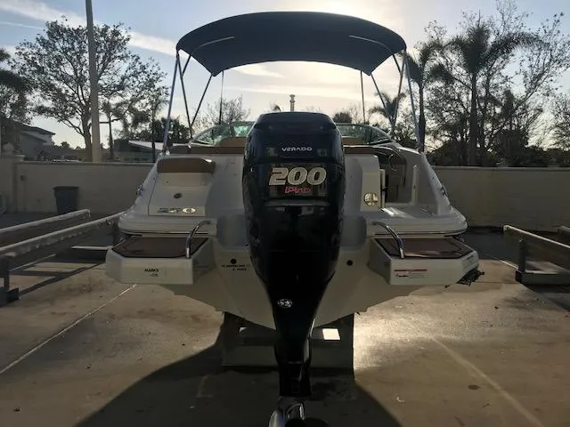 Slide: The Image of 2015 Sea Ray 220 Sundeck Outboard with 200 HP engine, parked outdoors. - 21