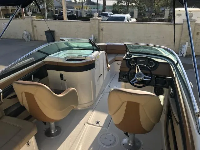 Slide: The Image of 2015 Sea Ray 220 Sundeck Outboard interior with dual seats and steering console. - 22