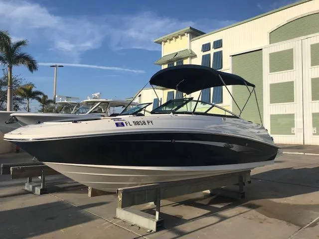 Slide: The Image of 2015 Sea Ray 220 Sundeck Outboard boat on display, featuring sleek design and canopy. - 23