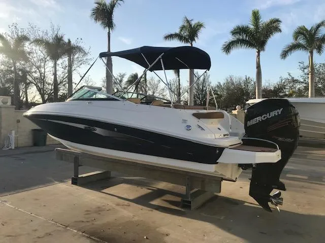 Slide: The Image of 2015 Sea Ray 220 Sundeck Outboard boat with Mercury engine, docked under palm trees. - 24