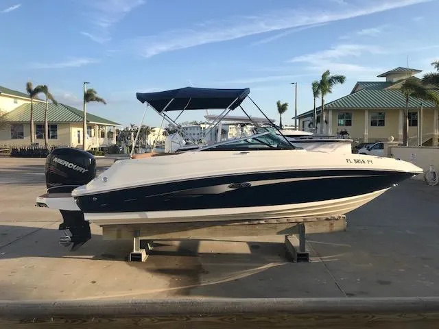 Slide: The Image of 2015 Sea Ray 220 Sundeck Outboard boat on display at a marina. - 27