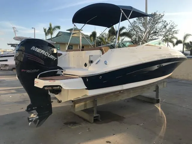 Slide: The Image of 2015 Sea Ray 220 Sundeck Outboard boat with Mercury engine, docked under a canopy. - 3