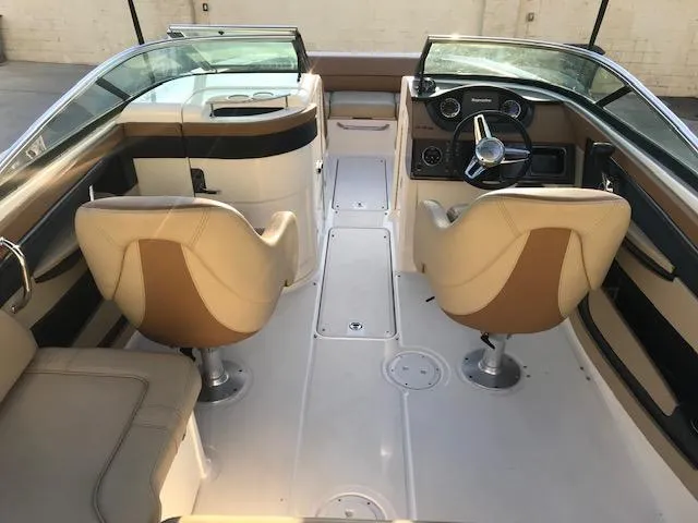 Slide: The Image of 2015 Sea Ray 220 Sundeck Outboard interior with beige seating and modern dashboard. - 30