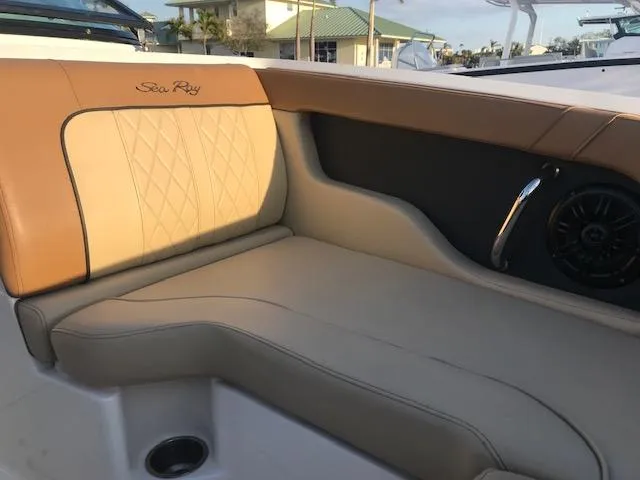Slide: The Image of 2015 Sea Ray 220 Sundeck Outboard interior seating with tan upholstery and speaker. - 31