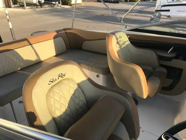 Slide: The Image of 2015 Sea Ray 220 Sundeck Outboard interior with beige seating and embroidered logo. - 33