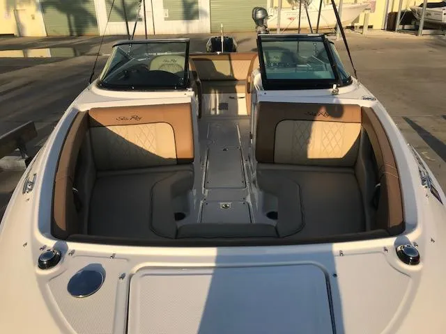 Slide: The Image of 2015 Sea Ray 220 Sundeck Outboard boat interior with tan seating and dual windshields. - 34