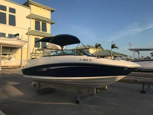 Slide: The Image of 2015 Sea Ray 220 Sundeck Outboard boat on display at a marina. - 5