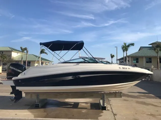 Slide: The Image of 2015 Sea Ray 220 Sundeck Outboard boat on display, featuring a sleek design and bimini top. - 8