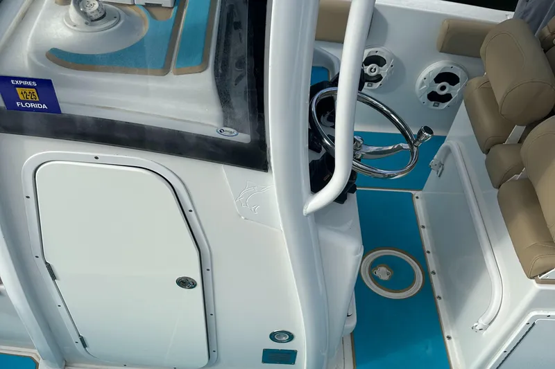 Slide: The Image of 2018 Sea Hunt 25 Gamefish boat interior with steering wheel and seating. - 13