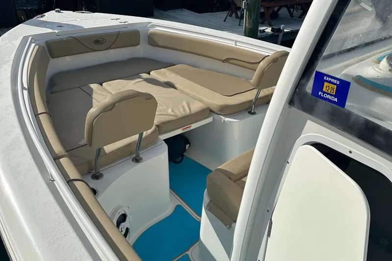 Slide: The Image of 2018 Sea Hunt 25 Gamefish boat interior with cushioned seating and Florida registration sticker. - 20