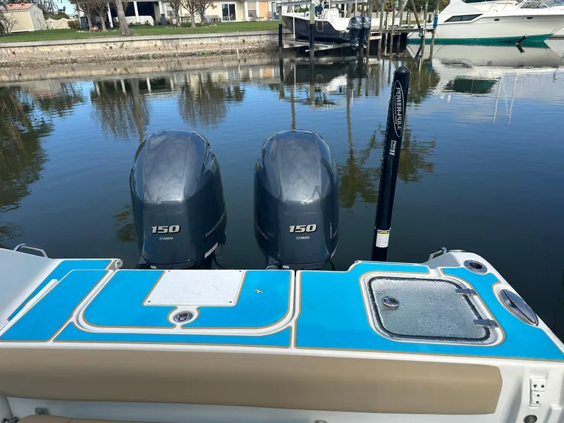 Slide: The Image of 2018 Sea Hunt 25 Gamefish boat with twin 150 engines docked by the water. - 23