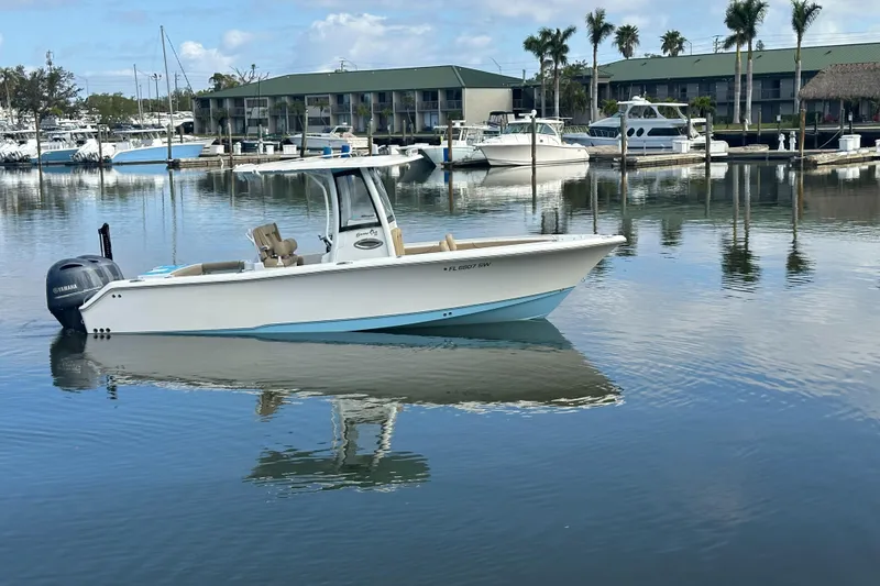 Slide: The Image of 2018 Sea Hunt 25 Gamefish boat docked in a marina with calm waters. - 24