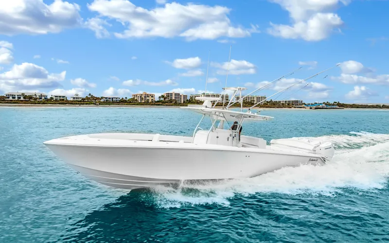 Slide: The Image of 2017 Bahama Center Console boat cruising on clear blue water under a partly cloudy sky. - 0