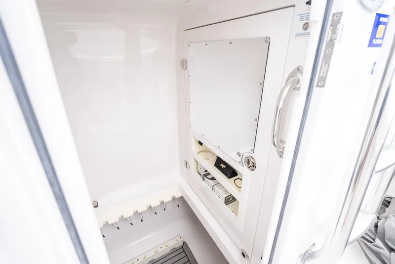 Slide: The Image of 2017 Bahama Center Console interior storage compartment with white finish and secure latch. - 12