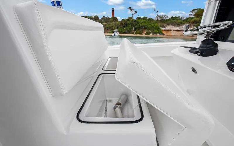 Slide: The Image of 2017 Bahama Center Console boat with open storage compartments, steering wheel, and scenic background. - 16