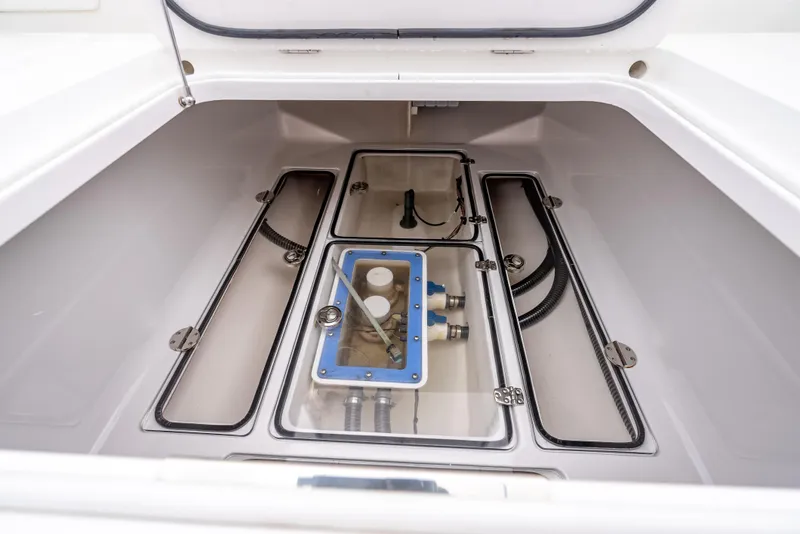 Slide: The Image of 2017 Bahama Center Console boat storage compartment with visible wiring and components. - 28