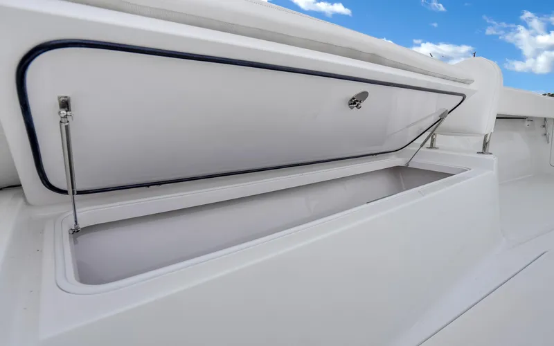 Slide: The Image of 2017 Bahama Center Console boat storage compartment open under blue sky. - 35