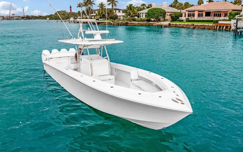 Slide: The Image of 2017 Bahama Center Console boat on turquoise water near luxury waterfront homes. - 41